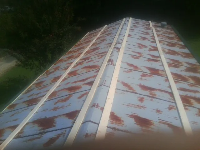 Rusted metal roof panels with new wood purlins before replacement — Storm Damage Roof Repair in Emmett by Roofing Brothers